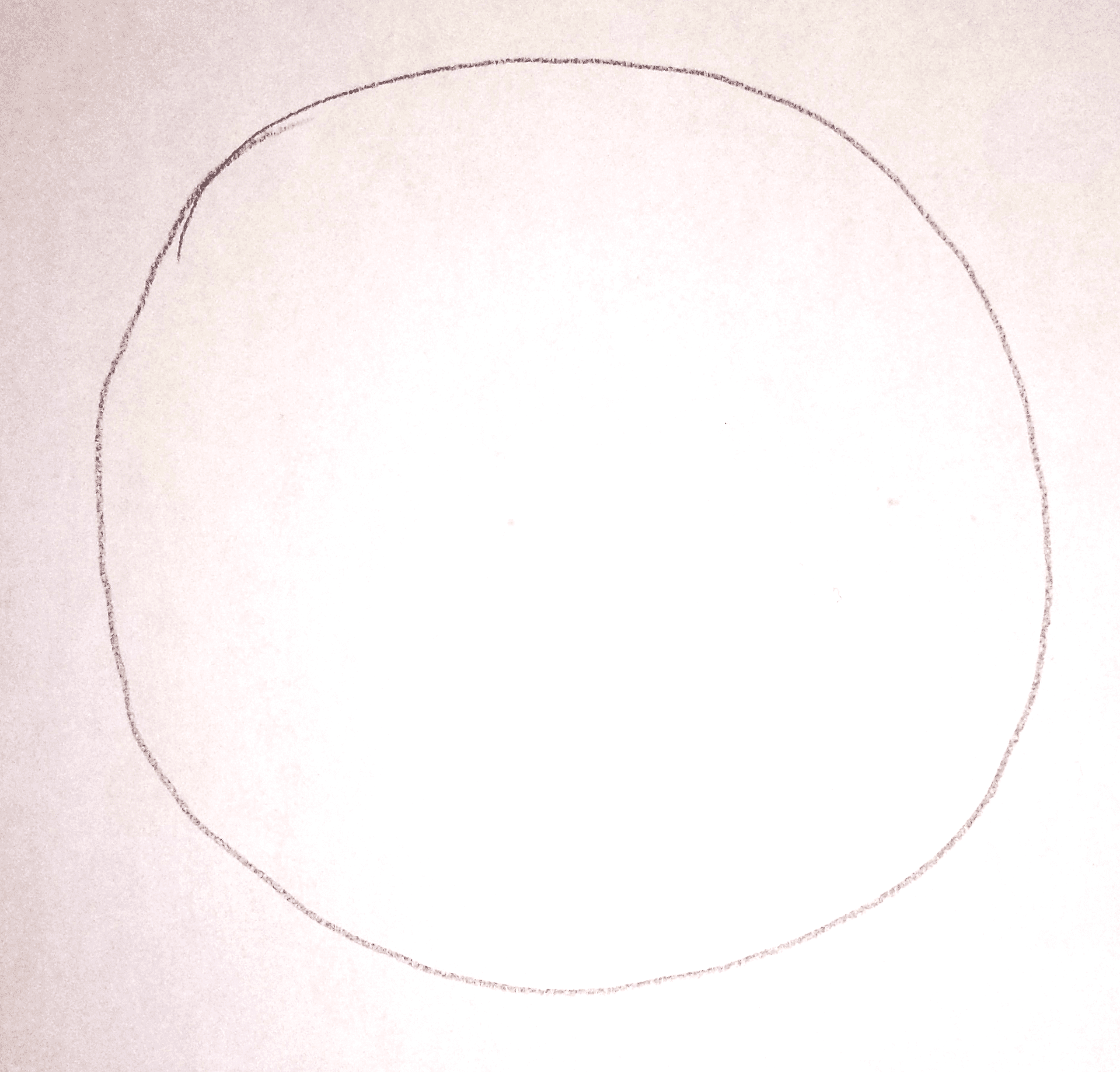 Hand drawing a circle on white paper with a pencil